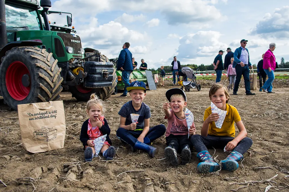 kinderen die op het aardappelveld zitten met een brammetje