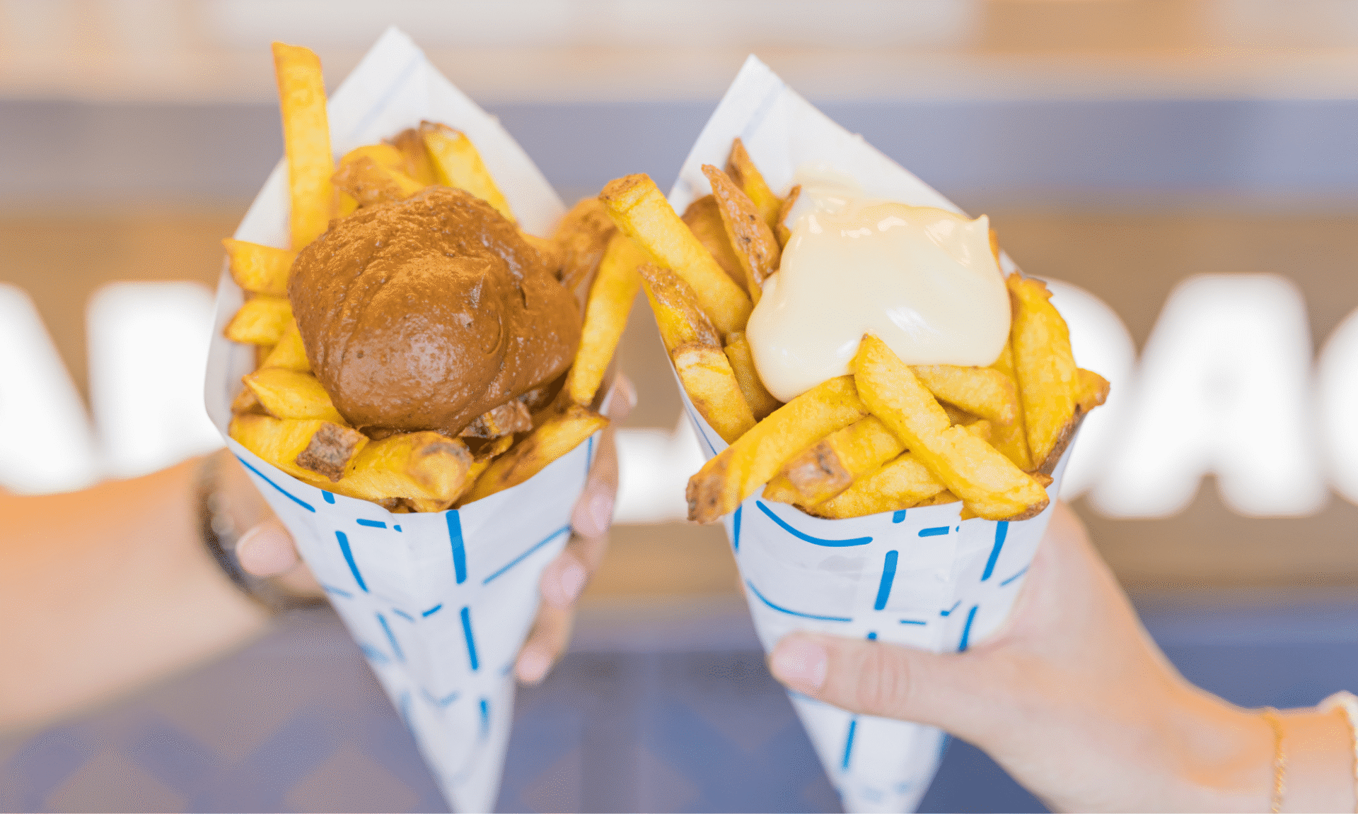 een close-up van een brammetje met huisgemaakte pindasaus en een brammetje met fritessaus