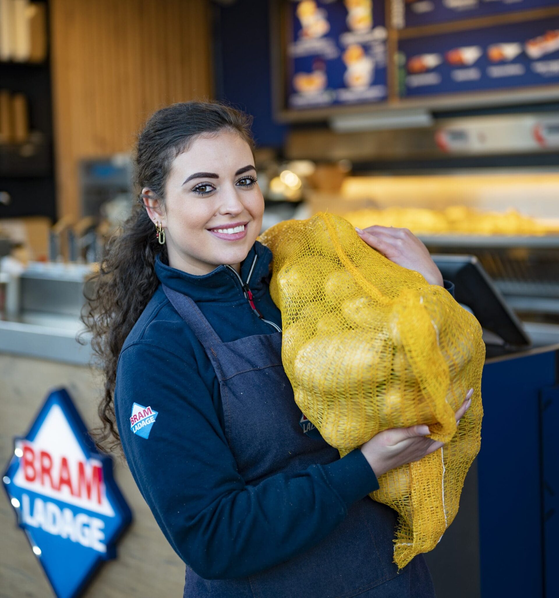 bram ladage franchisenemer met zak aardappels over haar schouder